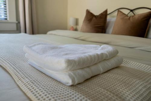 a pile of towels sitting on top of a bed at Historic Orlando Casita Love Apt A with backyard in Orlando