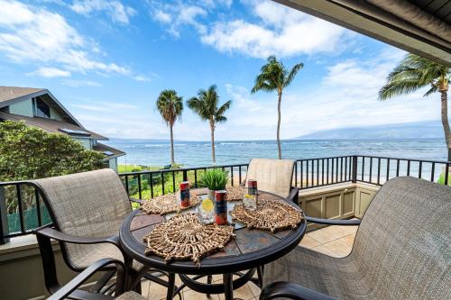 a table on a balcony with a view of the ocean at Kahana Village 3 · KHV 3 Remodeled 2BD Condo with Oceanfront Lan in Kahana