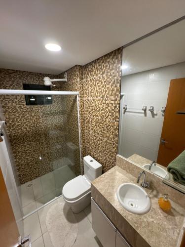 a bathroom with a toilet and a shower and a sink at Apartamento de um quarto com varanda externa in Bananeiras