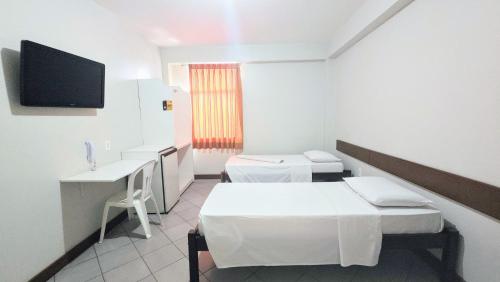 a hospital room with two beds and a tv at Pousada Central in Feira de Santana