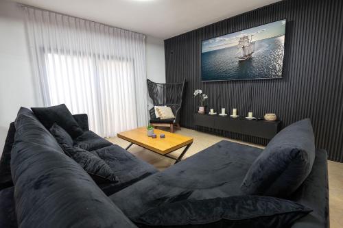 ein Wohnzimmer mit einem großen Sofa und einem Tisch in der Unterkunft סוויטה פלואלס בוטיק in Shahar