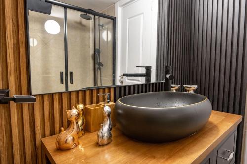 ein Badezimmer mit einem großen Spülbecken auf einer Holztheke in der Unterkunft סוויטה פלואלס בוטיק in Shahar