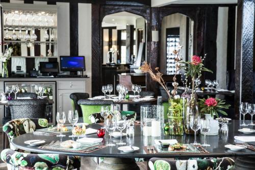 a dining room with tables and chairs with glasses at Hogarths Stone Manor in Kidderminster