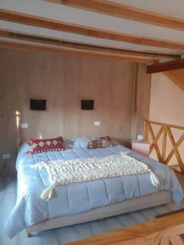 a large bed in a bedroom with a wooden ceiling at Lo de Pere in San Carlos de Bariloche