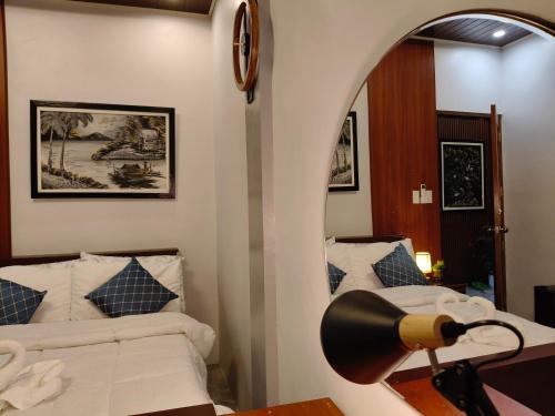 a bedroom with a bed and a lamp on a table at Goldland Caelestis Guest House in Bacolod