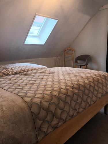 un lit dans une chambre avec une fenêtre dans l'établissement Le 289 Audruicq, à Audruicq