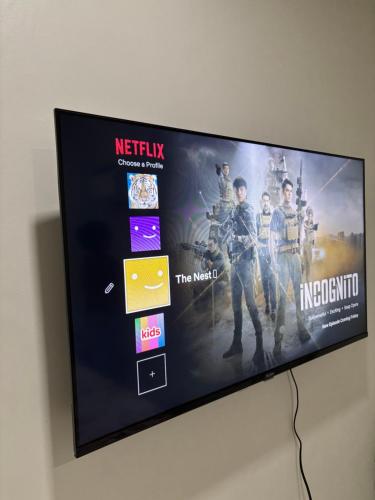 a flat screen tv hanging on a wall at The Nest- Your home when you roam in Dumaguete in Dumaguete