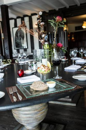 a table with a plate of food and wine glasses at Hogarths Stone Manor in Kidderminster