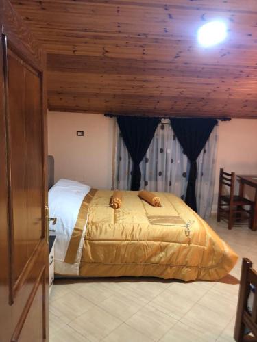 a large bed in a room with a wooden ceiling at Bar Kafe Pjetri Guest House in Patza-Kuqani