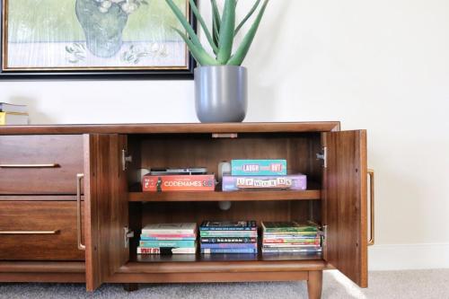 a book shelf with books and a potted plant at Mountain Whispers Harrisonburg JMU Shenandoah National Park in Harrisonburg