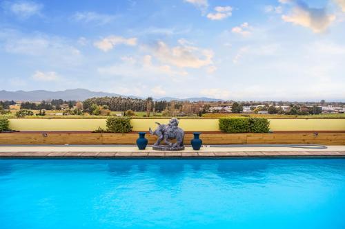 a statue sitting next to a swimming pool at Mountainview Villa Suite in an 6-bedroom Villa in Blenheim