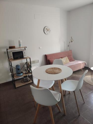 un salon avec une table, des chaises et un canapé dans l'établissement Castèléma - Appartement proche du sanctuaire, à Lourdes