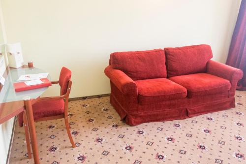 a living room with a red couch and a table at Caro Hotel in Bucharest