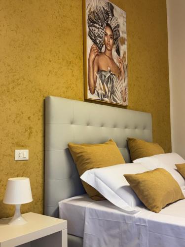 Un dormitorio con una cama con un cuadro en la pared. en Crispi 120 Rooms New Opening, en Palermo