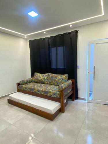 a couch in a room with a black curtain at Seu Lar de Praia p Família e amigos 400m do Mar em Condomínio in Praia Grande