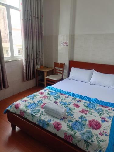 a bedroom with a bed with a floral bedspread at Hotel Phương Linh 360 phạm hùng in Ho Chi Minh City