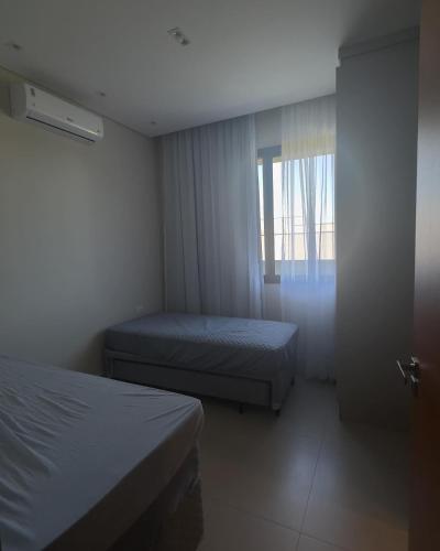 a hotel room with two beds and a window at Rivieira Santa Cristina XIII FJR in Paranapanema