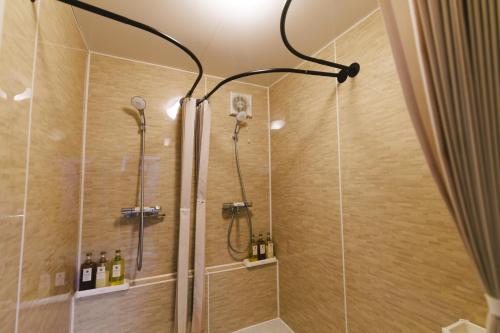 a shower with a shower head in a bathroom at 雪场缆车站旁-汤泽雪の宿-Ski IN Ski OUT-全新装修 in Seki
