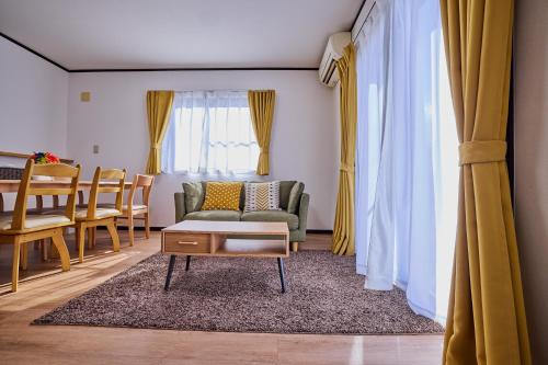 a living room with a couch and a table at APROStay富士河口湖松山16 in Fujiyoshida