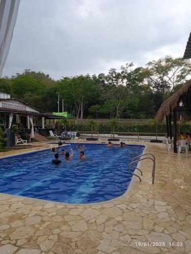 a group of people in a swimming pool at hosteria y camping piedras verdes in Sopetran