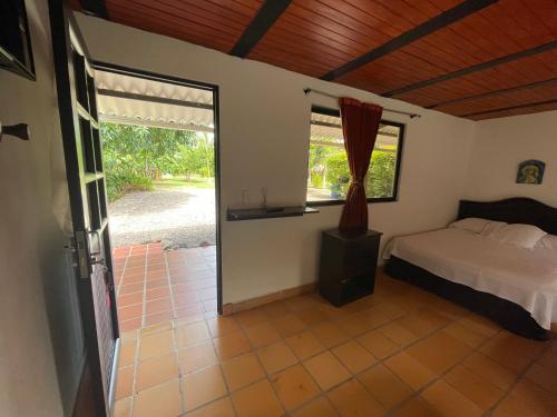 a bedroom with a bed and a large window at El Rincón de Carmentea, Casa de Campo para familias y amigos in Restrepo