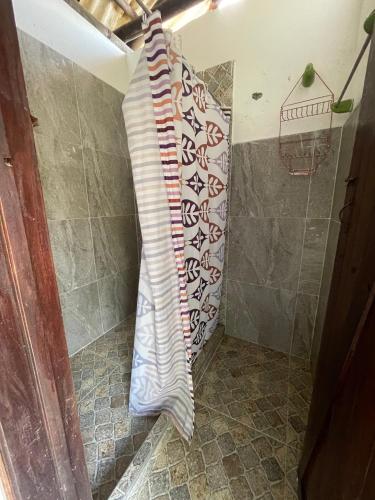 a shower curtain is hanging in a bathroom at El Rincón de Carmentea, Casa de Campo para familias y amigos in Restrepo
