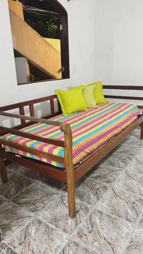 a wooden bed with two yellow pillows on it at La Mar Paraty Hospedaria 05 in Paraty