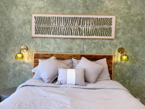 a bed with white pillows and a picture on the wall at Casa Palma in Xochitepec