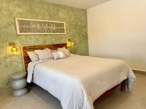 a bedroom with a large bed with white sheets at Casa Palma in Xochitepec