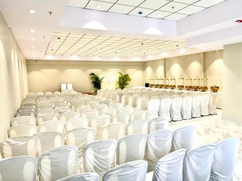 a banquet hall with white chairs in a room at The Beacon Hotel Visakhapatnam in Visakhapatnam