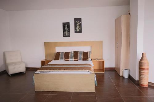a bedroom with a bed and a chair in it at Hotel Portobelo Guatape in Guatapé
