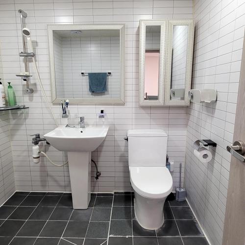 a bathroom with a toilet and a sink and mirror at Como House in Daegu