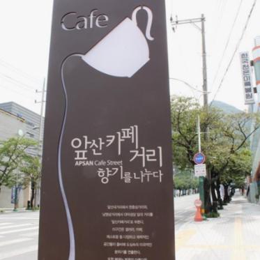 a sign with a tea kettle on the side of a street at Como House in Daegu