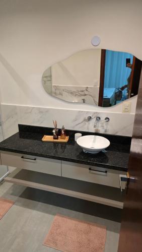a bathroom with a sink and a mirror at Maravilhosa casa linear 5 suítes em Angra in Angra dos Reis