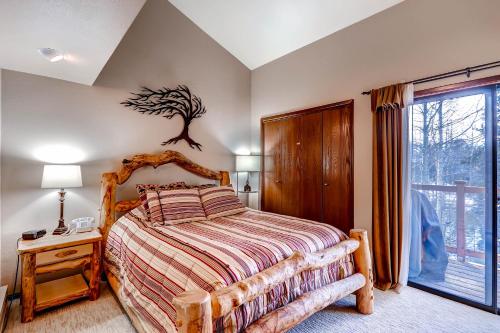a bedroom with a bed with a tree on the wall at The Forest Neighborhood by Keystone Resort in Keystone