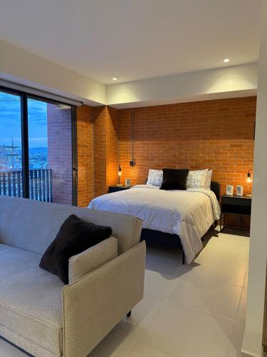 a bedroom with a bed and a couch at Stylish New Loft in Financial Zone and Downtown in Guadalajara
