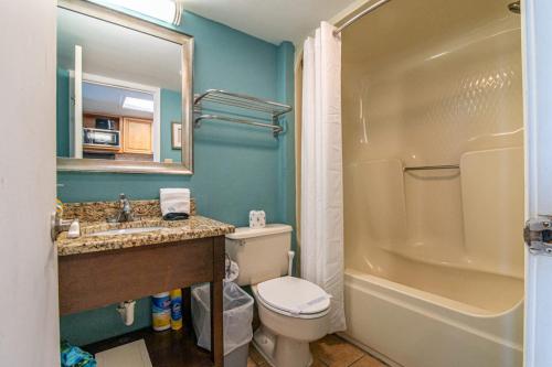 a bathroom with a toilet and a sink and a tub at Ocean Front Escape with Lazy River in Myrtle Beach