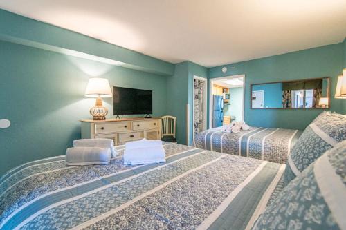 a bedroom with two beds and a flat screen tv at Ocean Front Escape with Lazy River in Myrtle Beach