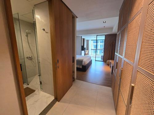 1 dormitorio y baño con ducha a ras de suelo. en de' Asasta Apartment Benoa N-511, en Nusa Dua