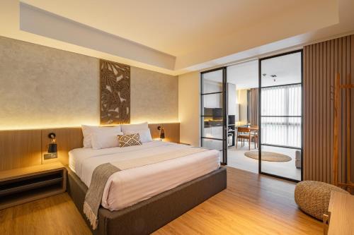Un dormitorio con una cama grande y un balcón. en de' Asasta Apartment Benoa N-511, en Nusa Dua