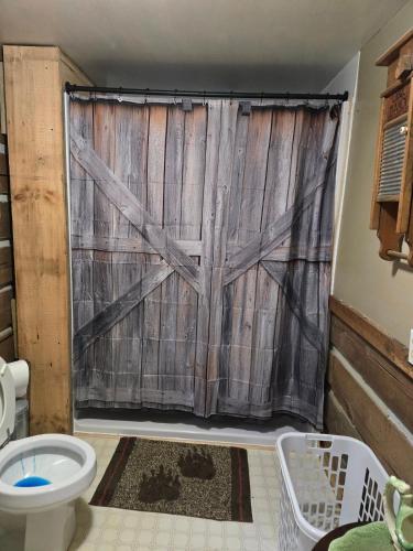 a bathroom with a sliding barn door with a toilet at Mountain Memories Cabin Rental in Booneville