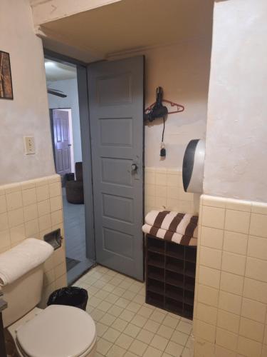 Un baño con inodoro, lavabo y puerta. en Casa en La zona Centro de la Ciudad, en Ciudad Juárez