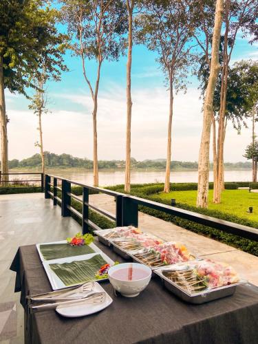 a table with food on it with a view of a river at River Tree Resort in Chiang Khan
