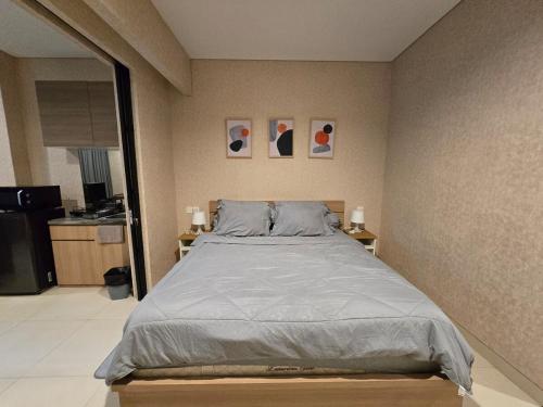 Un dormitorio con una cama y dos cuadros en la pared. en de Asasta Apartment Benoa E-105, en Nusa Dua