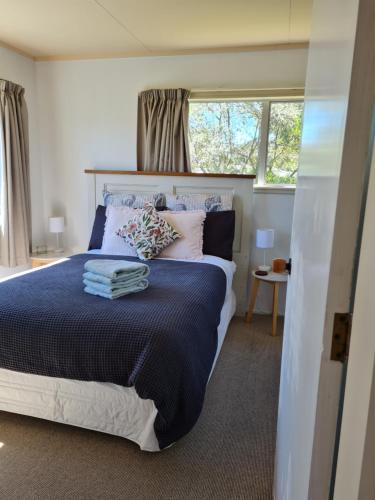 a bedroom with a large bed and a window at Seaside Tahuna in Nelson