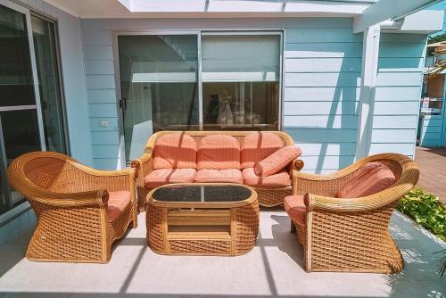 a patio with wicker furniture and a table and chairs at Waterfront Oasis at Central Coast in Tascott