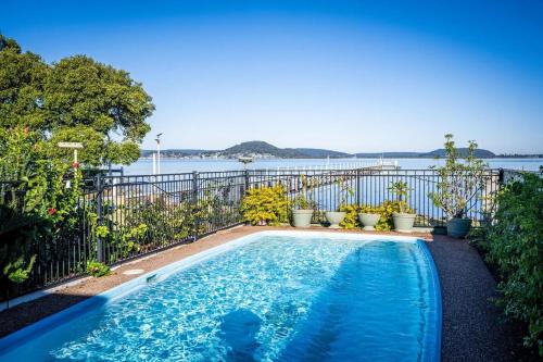 a swimming pool with a view of the water at Waterfront Oasis at Central Coast in Tascott