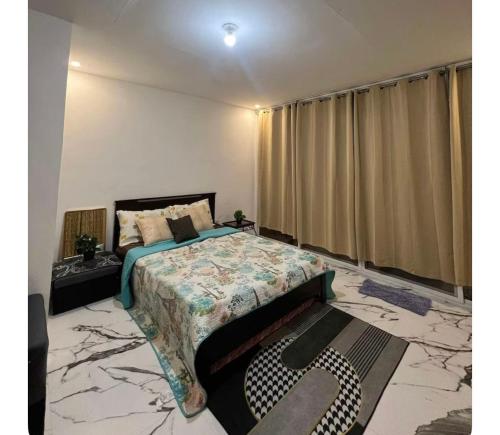 a bedroom with a king sized bed with a marble floor at La Casa Cita in Indang