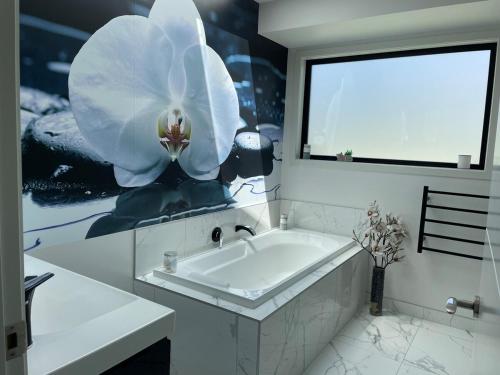La salle de bains est pourvue d'une baignoire et d'une grande fleur sur le mur. dans l'établissement Albert Town Retreat, à Albert Town
