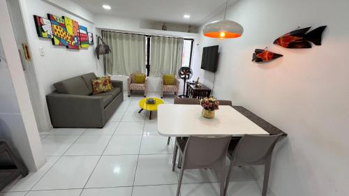a living room with a table and a couch at FLAT MAR E SOL 106 A 50m PRAIA in Porto De Galinhas